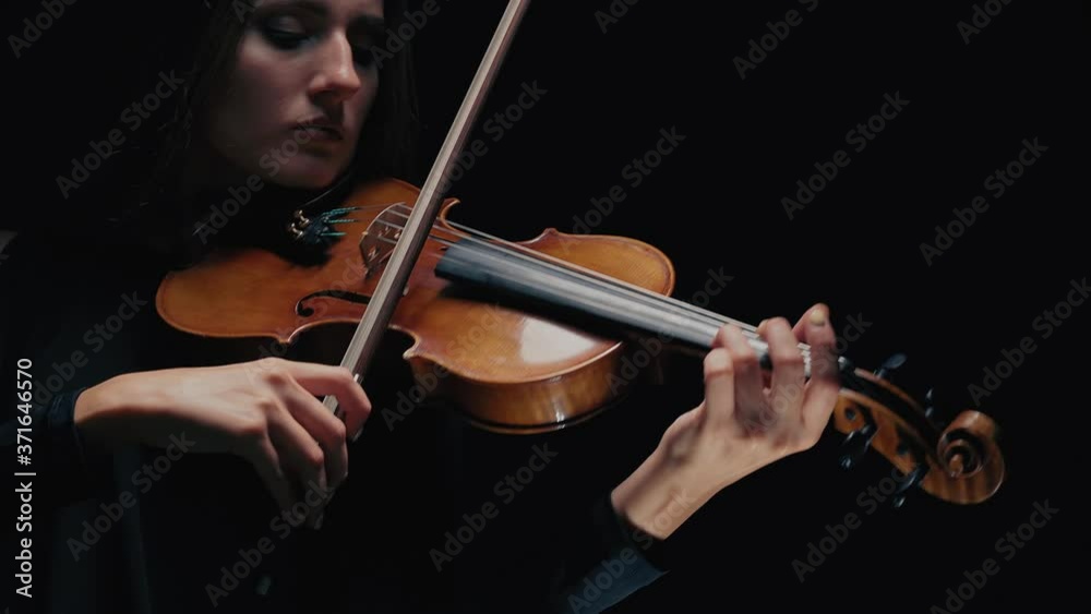 Girl violin musician playing at studio. Studio black background