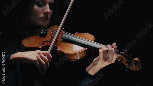 Girl violin musician playing at studio. Studio black background