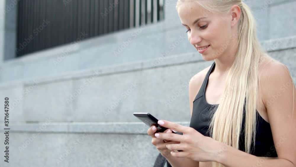 Cheerful pretty girl smiling chatting on smartphone instead of workout, laziness Cheerful pretty girl smiling chatting on smartphone instead of workout, laziness