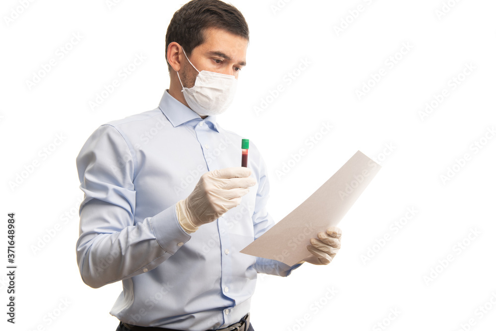 Doctor holding vacuum test tube with blood and studying the blood test sheet Doctor holding vacuum test tube with blood and studying the blood test sheet