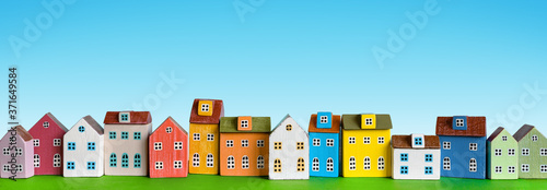 Row of wooden miniature colorful retro houses on blue background