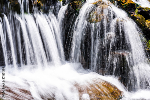 The stones under the waterfall, close-up waterfall as background.