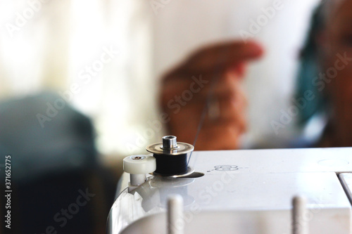 Tailor wrapping a bobbin on the sewing machine