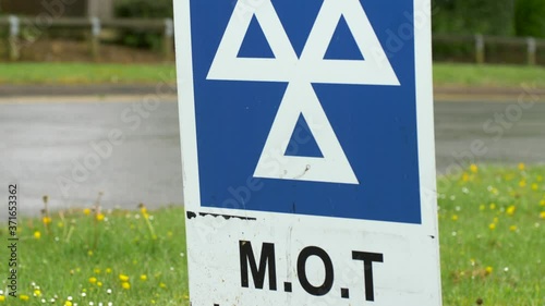 blue MOT service sign on british road on cloudy rainy day