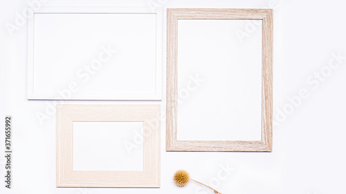 Summer composition. Three wooden frames with empty space for text. There is dried grass at the bottom. Everything is arranged on a white background. Flat top view.