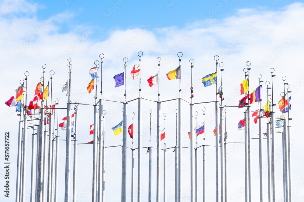 A lot of national flags of european countries on flagpoles abova blue sky. Concept of global union A lot of national flags of european countries on flagpoles abova blue sky. Concept of global union
