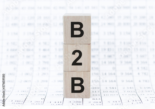 B2B, business to business marketing, business word on wooden cubes over background of numbers