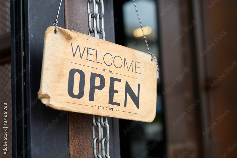 Open sign in coffee shop door , business reopen After Covid-19 outbreak concept .