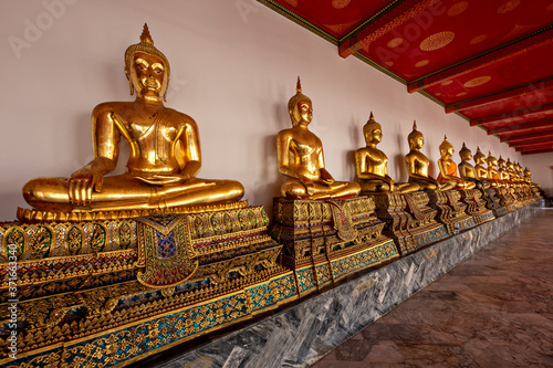 Row of Buddha statues in the Buddhist Temple known as Wat Pho, in Bangkok, Thailand © MehmetOZB