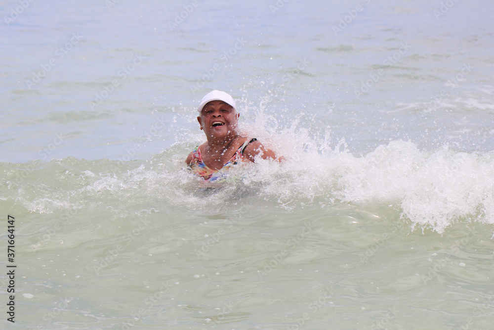 Lady playing  in the water and waves of the ocean at the beach