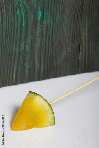 Pieces of yellow watermelon on sticks.