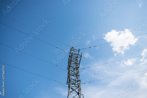 power line with wires in different directions on the background of a blue sky with clouds.