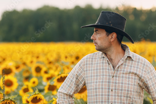 Man farmer standing in a sunflower field
