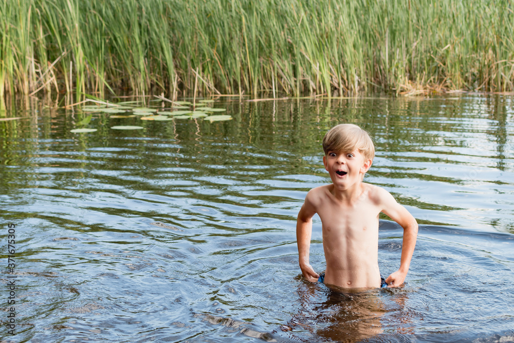 Fototapeta premium Little boy swimming in the lake
