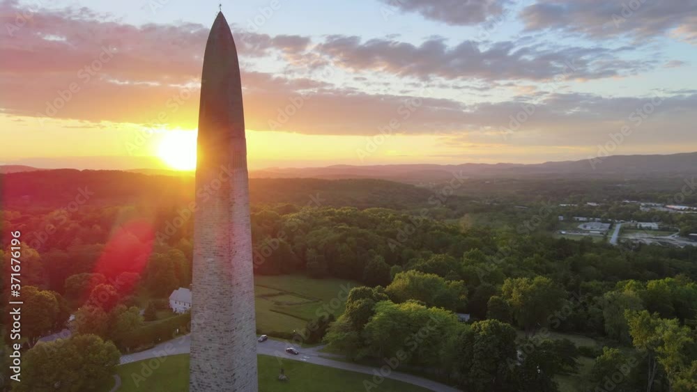 Aerial 4k video of Bennington Monument. Fast-paced drone shot flying upwards with tilt down and lens flare.