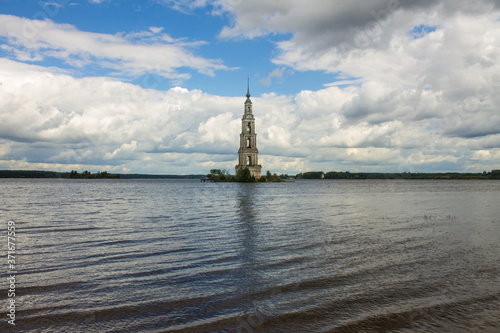 a flooded old bell tower in the middle of a river against a cloudy dramatic sky and a space to copy in Kalyazin Russia
