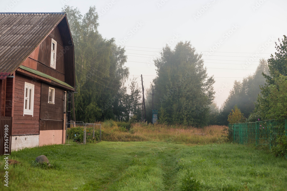 Obraz premium Rural landscape on a early foggy morning in the village.