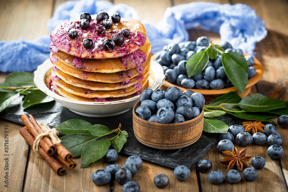 Blueberries in a plate and pancakes, on an old background. Blueberries in a plate and pancakes, on an old background.