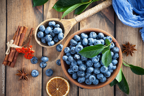Fototapeta Naklejka Na Ścianę i Meble -  Ripe, fresh blueberries in a wooden bowl on an old background.