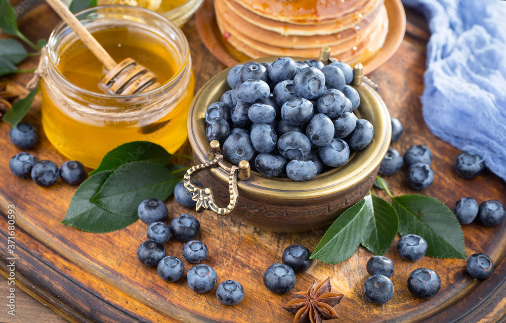 Ripe, fresh blueberries in a wooden bowl on an old background. Ripe, fresh blueberries in a wooden bowl on an old background.