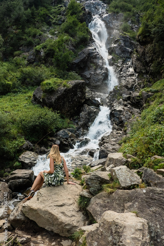 Urlauberin sitzt vor einem Wasserfall in der Steiermark