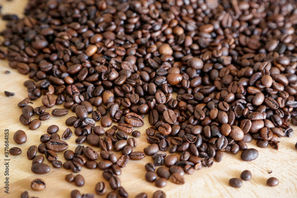 Fototapeta premium Coffee grains on wooden table, with natural light