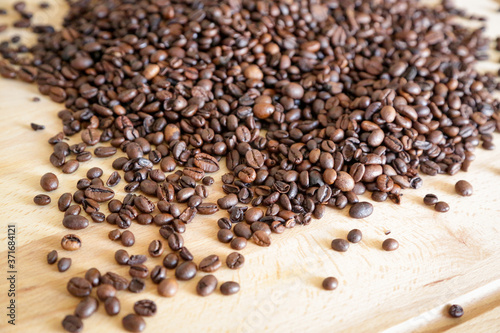 Coffee grains on wooden table  with natural light