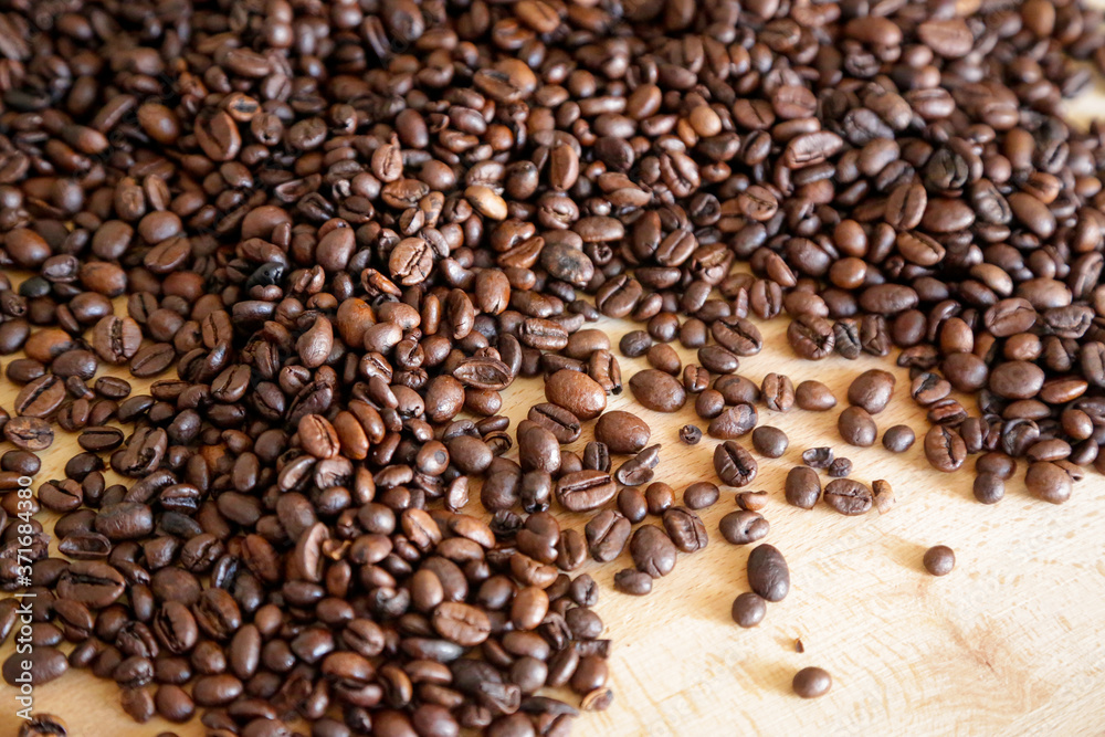 Fototapeta premium Coffee grains on wooden table, with natural light