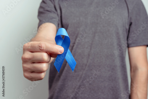 Man showing dark blue ribbon. Awareness ribbon.