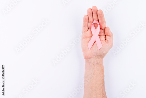 Pink ribbon over palm. White background.