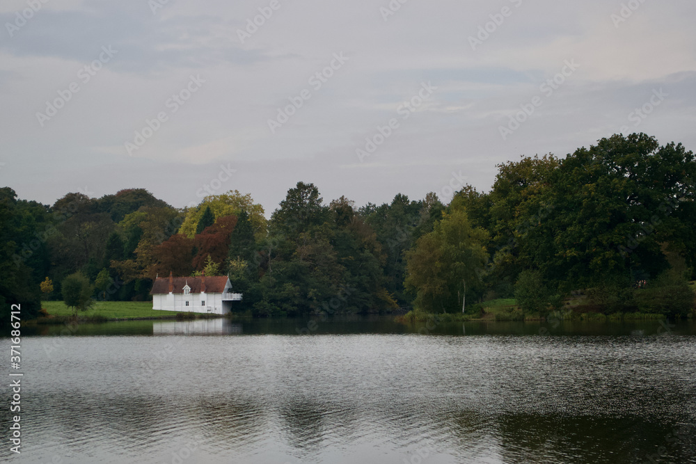 White boathouse on a wooded lake