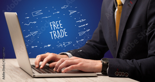Obraz na plátně Businessman working on laptop with FREE TRADE inscription, online shopping conce