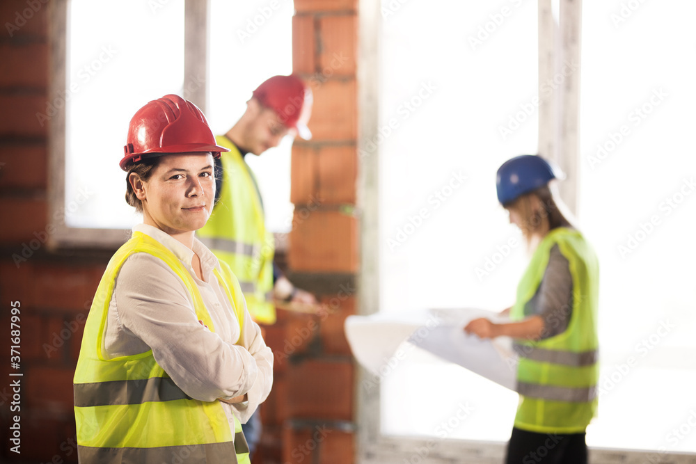 worker, investor, inspector or architect with her team. construction site engineers on site. satisfied expression