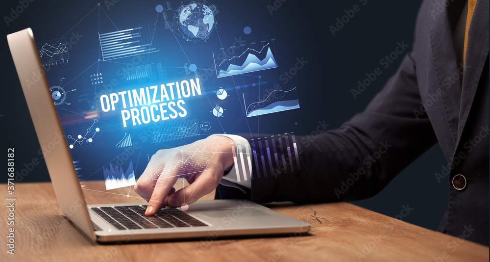 Businessman working on laptop with OPTIMIZATION PROCESS inscription, new business concept Businessman working on laptop with OPTIMIZATION PROCESS inscription, new business concept