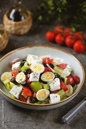 Greek salad with quail eggs. Salad with peppers  tomatoes  cucumbers  feta  oregano  olives  onions  olive oil and lemon juice.
