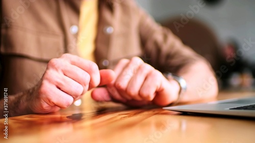 The scene of the gestures of a man next to a laptop