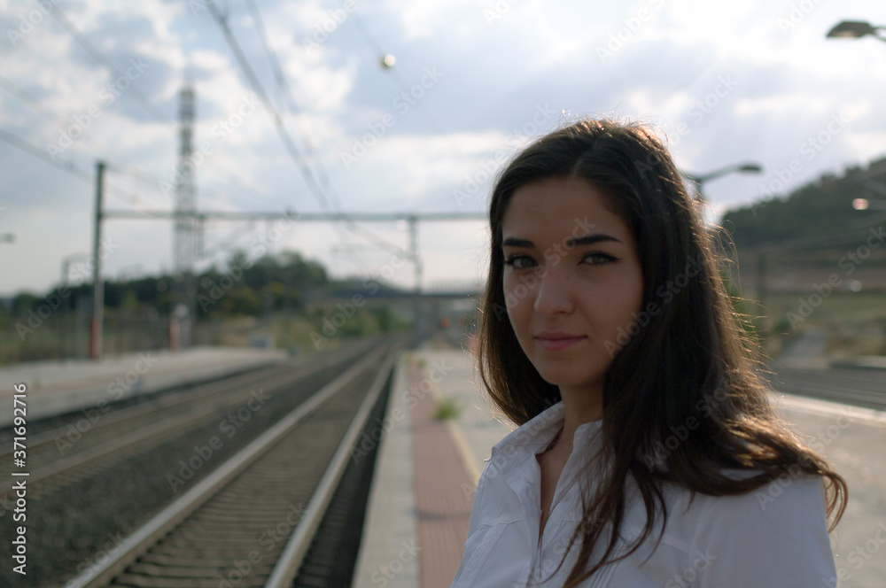 Young man looking along rail of train tracks. Young man looking along rail of train tracks.