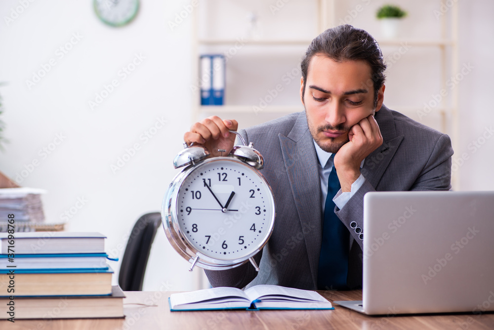 Young male businessman reading books at workplace Young male businessman reading books at workplace