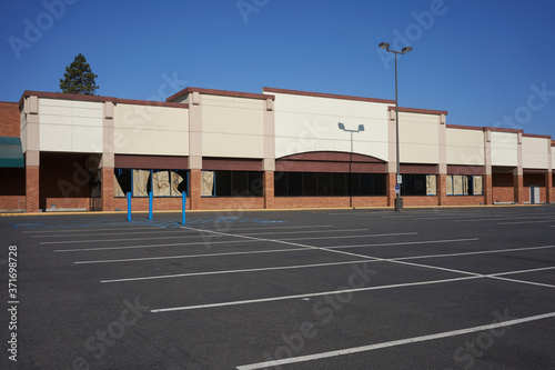 An out-of-business retail place with its empty parking lot in Portland, Oregon, during a pandemic summer.