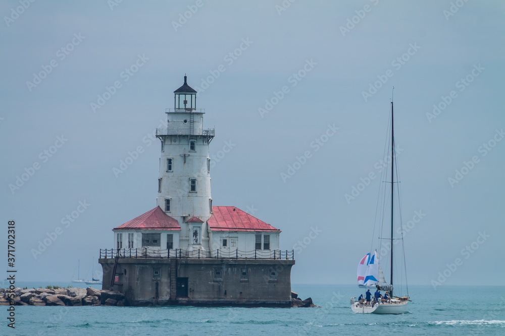 Sailboat Sailing Past The Chicago Harbor Lighthouse on Lake Michigan, Chicago, Illinois, USA