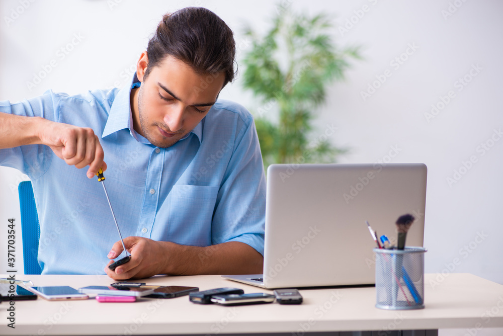 Young male technician repairing mobile phone Young male technician repairing mobile phone