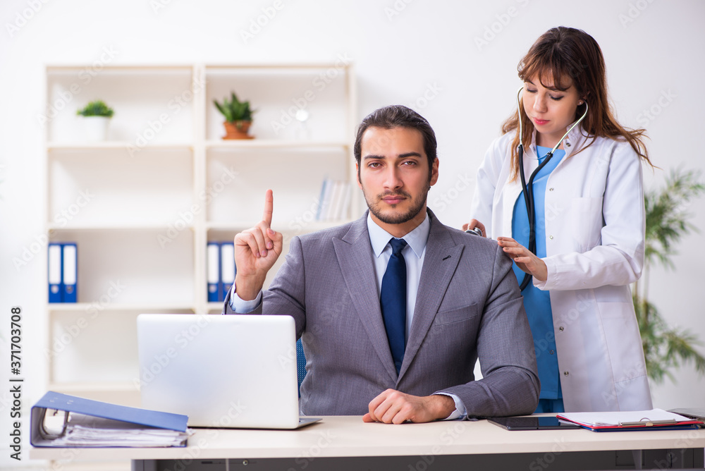Obraz premium Young female doctor and sick businessman in the office