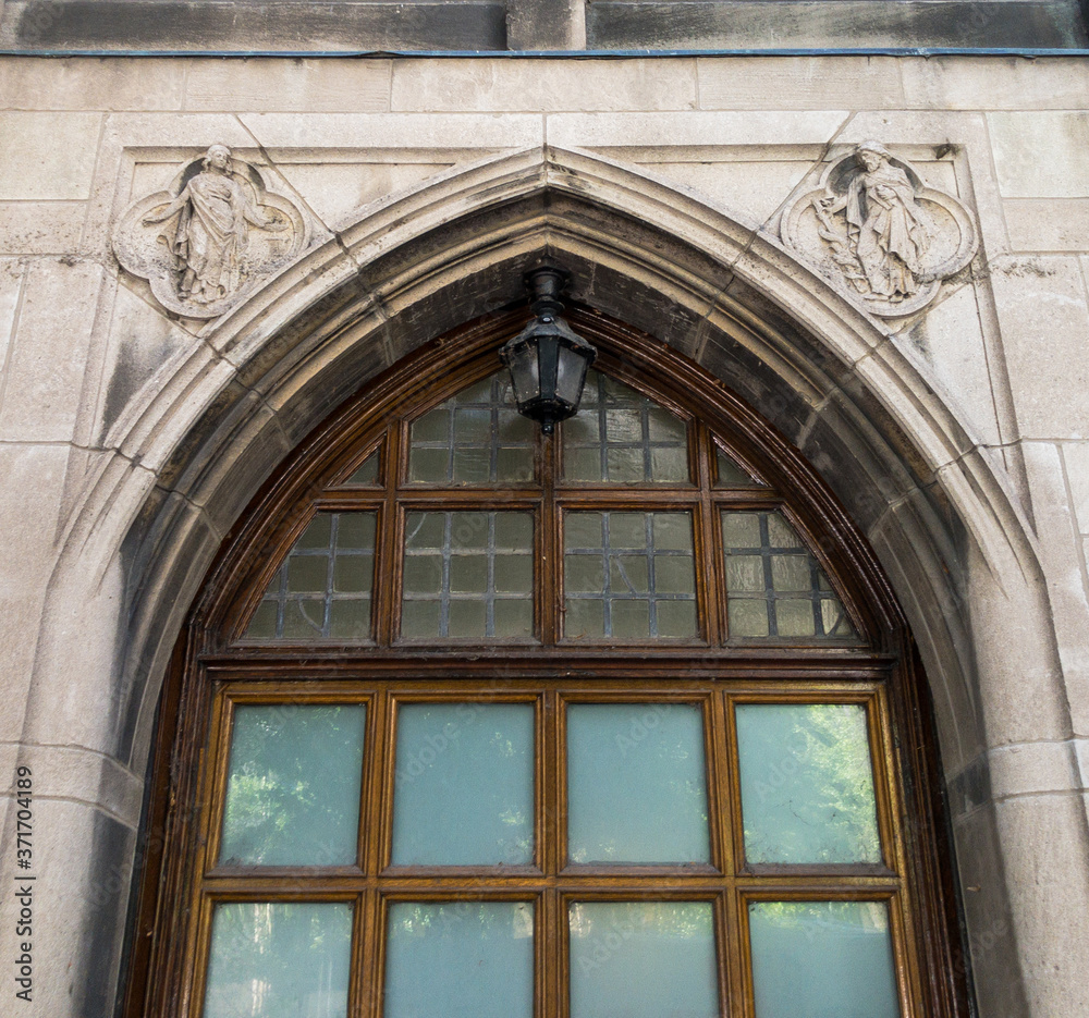arched gothic doorway with concrete design, lead glass and  center lantern in Chicago