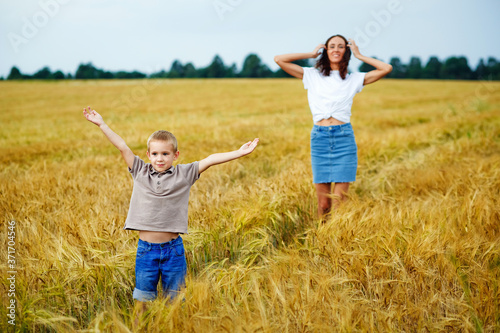 Happy family mom and son in a summer wheat field.