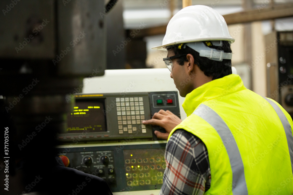 Engineers operating a machine in factory Engineers operating a machine in factory