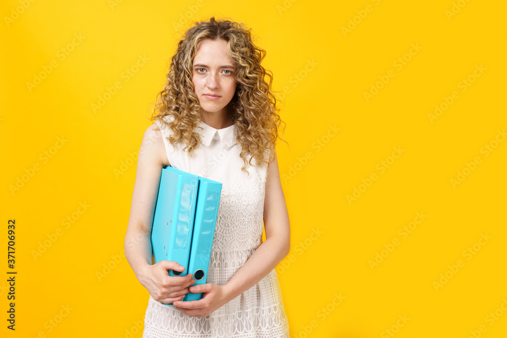 A young woman holds folders with documents in her hands.