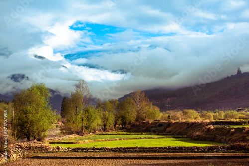 Landscape with mountains and clouds, Early Morning sunrise with mountains and clouds. Serine view of Paro Valley, Paro River, Mountain Ranges, and paddy fields of Paro, Bhutan.