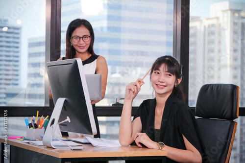 Business Lady officers discussing and working or using computer on desk in office with colleagues talking together with team