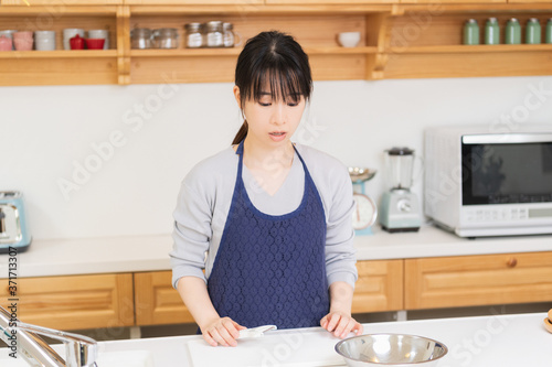 キッチンに立つエプロンを着た若い女性