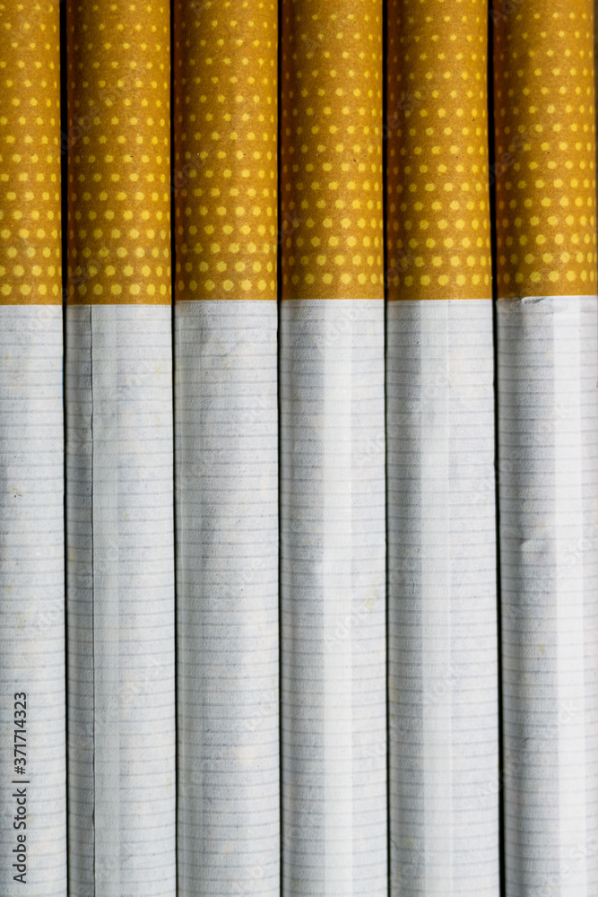 Tobacco cigarettes standing vertically on a table
Tobacco cigarettes standing vertically on a table